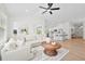 Bright living room with white walls, modern fan, and cozy sectional couch with a clear view to the kitchen at 4105 Waterville Ave, Wesley Chapel, FL 33543