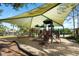 Community playground offers shade over slides and playground equipment on a cushioned, mulch surface at 4105 Waterville Ave, Wesley Chapel, FL 33543