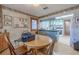 Bright eat-in kitchen features sunflower accents, a round wood table, and blue cabinets with granite countertops at 503 Chestnut St, Oldsmar, FL 34677