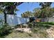 Backyard garden featuring a stone bench, mature landscaping, and a white vinyl fence at 5072 98Th Way, St Petersburg, FL 33708