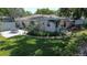Backyard featuring lush green grass, patio, charming home exterior, and mature trees at 5072 98Th Way, St Petersburg, FL 33708