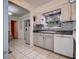 Kitchen features updated gray cabinets, tile floors and backsplash, and white appliances at 5072 98Th Way, St Petersburg, FL 33708
