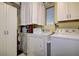 Compact laundry room featuring a washer, dryer, and storage cabinets at 5072 98Th Way, St Petersburg, FL 33708