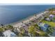 Overhead view of a tranquil beach with shelters, palm trees, parking area, and adjacent waterfront residences at 5537 Sea Forest Dr # 304, New Port Richey, FL 34652