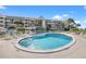Community pool with lounge chairs and building in background at 5537 Sea Forest Dr # 304, New Port Richey, FL 34652