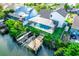 Aerial view of a waterfront property with a screened-in pool, private dock, and lush landscaping at 6509 Dolphin Cove Dr, Apollo Beach, FL 33572