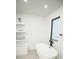 Bright bathroom with a modern bathtub next to a window, and storage shelves with decorative accents at 6509 Dolphin Cove Dr, Apollo Beach, FL 33572