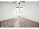 Sunlit bedroom featuring neutral carpet, white walls, ceiling fan and corner windows at 6509 Dolphin Cove Dr, Apollo Beach, FL 33572