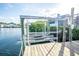Boat lift and dock on waterfront with lush greenery and clear skies above at 6509 Dolphin Cove Dr, Apollo Beach, FL 33572