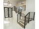 Modern staircase with wooden steps and black metal railings, leading to upper levels with stylish design at 6509 Dolphin Cove Dr, Apollo Beach, FL 33572