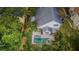 A birds-eye view of a home and backyard featuring a sparkling blue pool and lush trees at 678 Greenglen Ln, Palm Harbor, FL 34684