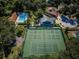 Aerial view of community tennis courts and pool surrounded by lush greenery at 678 Greenglen Ln, Palm Harbor, FL 34684