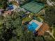Aerial view of community pool and tennis courts with lush greenery in a residential neighborhood at 678 Greenglen Ln, Palm Harbor, FL 34684