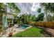 A backyard featuring a pool, lush landscaping, and a patio seating area at 678 Greenglen Ln, Palm Harbor, FL 34684