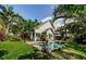 A backyard featuring a pool, lush tropical landscaping, and a paver patio at 678 Greenglen Ln, Palm Harbor, FL 34684