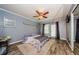 Cozy bedroom featuring wood floors, a ceiling fan, a comfortable bed, and a window at 678 Greenglen Ln, Palm Harbor, FL 34684