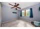 Bright bedroom featuring a ceiling fan, window, and neutral carpet at 678 Greenglen Ln, Palm Harbor, FL 34684