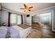 A well-lit bedroom with a ceiling fan, wood floors, and a large closet at 678 Greenglen Ln, Palm Harbor, FL 34684