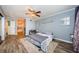 This bedroom has a ceiling fan, wood floors, and an open doorway to the bathroom at 678 Greenglen Ln, Palm Harbor, FL 34684