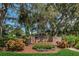 Community entrance sign surrounded by mature trees, lush landscaping, and mulch at 678 Greenglen Ln, Palm Harbor, FL 34684
