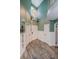 Bright foyer featuring hardwood flooring, white wainscotting, and a white front door at 678 Greenglen Ln, Palm Harbor, FL 34684