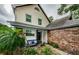 Two-story home with covered entry, brick accents, bench seating, and manicured landscaping at 678 Greenglen Ln, Palm Harbor, FL 34684