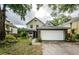 Home exterior with front lawn, brick details, driveway and two car garage at 678 Greenglen Ln, Palm Harbor, FL 34684