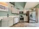 Modern kitchen with stainless appliances, French doors and wood-look tile flooring at 678 Greenglen Ln, Palm Harbor, FL 34684