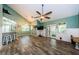 Spacious living room with vaulted ceilings, a ceiling fan and wood-look tile flooring at 678 Greenglen Ln, Palm Harbor, FL 34684
