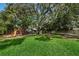 Community playground with swings, slides, picnic tables and mature shade trees at 678 Greenglen Ln, Palm Harbor, FL 34684