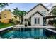 Backyard view of the two-story home from the pool featuring french doors and an outdoor bar at 678 Greenglen Ln, Palm Harbor, FL 34684