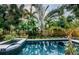 Backyard pool with tropical foliage surround and spa with tile trim is the perfect place to relax at 678 Greenglen Ln, Palm Harbor, FL 34684