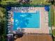 Aerial view of a sparkling community pool with lounge chairs and umbrellas at 678 Greenglen Ln, Palm Harbor, FL 34684