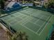Aerial view of tennis courts in a well-maintained community with greenery and landscaping at 678 Greenglen Ln, Palm Harbor, FL 34684