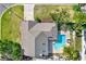 An aerial view of a well-maintained home featuring a private pool, palm trees, and a stone driveway at 680 Capri Blvd, Treasure Island, FL 33706