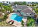 An inviting backyard featuring a sparkling pool, spacious patio, and lush landscaping at 680 Capri Blvd, Treasure Island, FL 33706