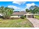 Charming single-story home featuring a lush front yard, brick driveway, and an attached garage, creating a welcoming curb appeal at 680 Capri Blvd, Treasure Island, FL 33706