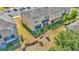 Aerial view of the townhouse with green lawn, trees, and a parking lot at 7021 White Treetop Pl, Riverview, FL 33578