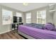 Bedroom with plank flooring, three windows, and television at 7021 White Treetop Pl, Riverview, FL 33578