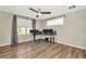 Comfortable bedroom with hardwood flooring, a modern ceiling fan, and natural light from windows at 7021 White Treetop Pl, Riverview, FL 33578