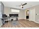Bedroom featuring wood-look flooring, ceiling fan, closet, and view into bathroom at 7021 White Treetop Pl, Riverview, FL 33578