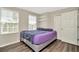 Bedroom featuring plank flooring, two windows, closet, and gray walls at 7021 White Treetop Pl, Riverview, FL 33578