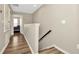 Upstairs hallway featuring stylish hardwood floors and a partial staircase at 7021 White Treetop Pl, Riverview, FL 33578
