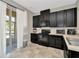Well-lit kitchen with black cabinetry, modern appliances, and sliding glass doors to the outside at 7021 White Treetop Pl, Riverview, FL 33578