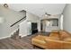 Spacious living room featuring stairs and dark wood-look floors, illuminated by a modern ceiling fan at 7021 White Treetop Pl, Riverview, FL 33578