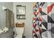 Bathroom with patterned shower curtain, gray walls, white fixtures, and functional storage at 7205 San Luis Ct, Tampa, FL 33634