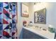 Stylish bathroom featuring a modern vanity, framed mirror, and decorative shower curtain accents at 7205 San Luis Ct, Tampa, FL 33634