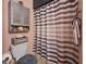 Bathroom featuring a toilet, storage, and a gray and white striped shower curtain for privacy at 7205 San Luis Ct, Tampa, FL 33634