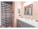 Bathroom with modern vanity, framed mirror, and a stylish striped shower curtain for added flair at 7205 San Luis Ct, Tampa, FL 33634