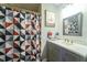 Bathroom features a modern vanity, framed mirror, and a geometric shower curtain for privacy at 7205 San Luis Ct, Tampa, FL 33634